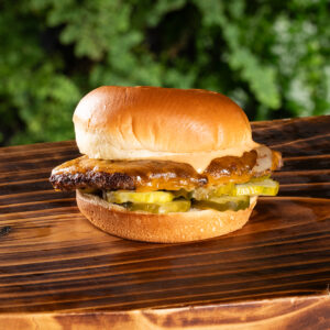 Cheeseburger with pickles on wood tray