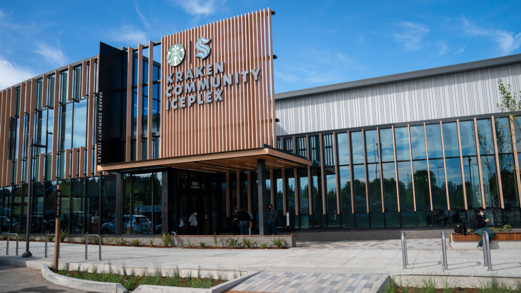 Exterior Image of Kraken Community Iceplex. Building with large glass windows and blue sky.