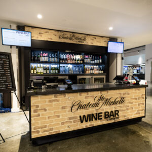 a bar with a display of wine bottles at Climate Pledge Arena